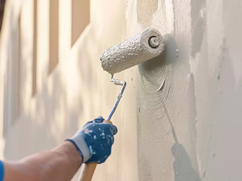 uomo-che-pittura-di-bianco-parete-con-rullo-milano Uomo che pittura di bianco parete con rullo Milano